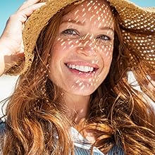 A red haired woman with a sun hat smiling