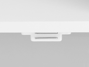 Nahaufnahme einer weißen Kunststoffverriegelung oder eines Verschlussmechanismus. Zwei horizontale Schlitze sind auf einem erhöhten rechteckigen Abschnitt sichtbar, der an einer größeren flachen Fläche befestigt ist