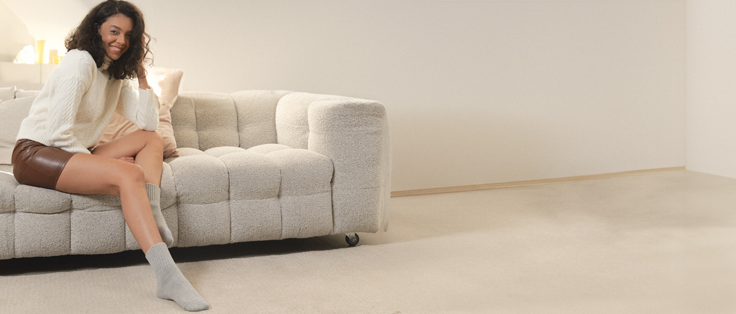 un sofá blanco sentado en una habitación al lado de una pared.