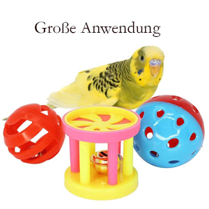 Buntes Spielzeug für Haustiere, darunter ein gelbes Spielzeug in Vogelform, rote und blaue perforierte Bälle und ein rosafarbenes zylindrisches Objekt mit Löchern.