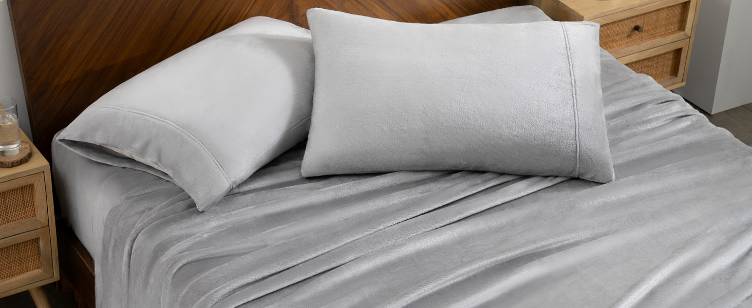close up of sheets on a bed, with two pillows with pillowcases
