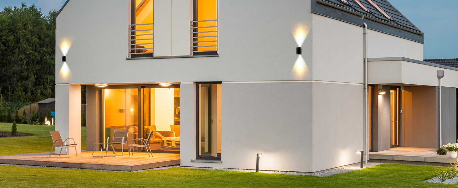 Modern white house exterior at dusk/evening, showing illuminated windows and architectural features from different angles.