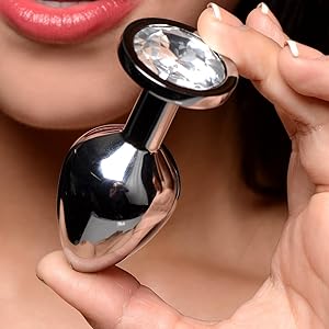 Analplug aus Edelstahl mit großem durchsichtigem Edelstein. Tropfenförmige Unterseite, schmaler Hals. Wird zwischen den Finger gehalten und zeigt Größe und