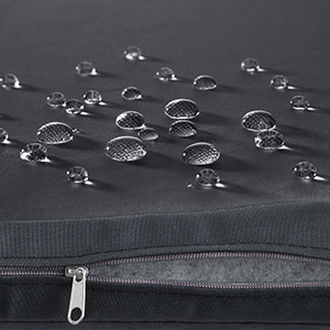 Gros plan d'un sac noir zippé avec des gouttelettes d'eau perlant sur sa surface résistante à l'eau, démontrant ses propriétés imperméables