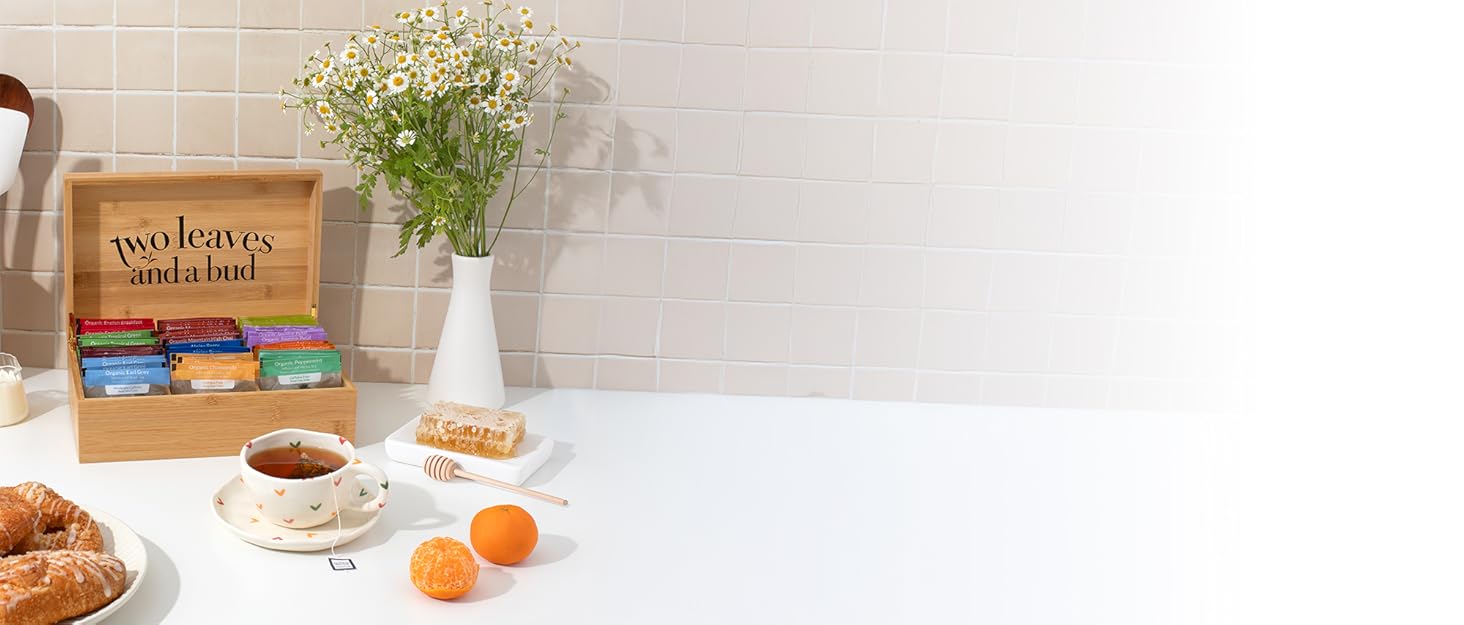 Two Leaves and a Bud bamboo tea chest on white counter with tea cup