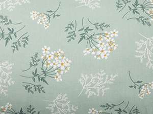 Zartes Stoff- oder Tapetendesign mit Blumenmuster mit kleinen weißen Blüten und graugrünen Blättern auf hellsalbeifarbenem