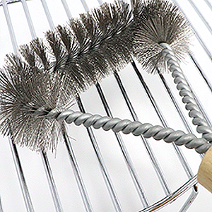 grill brush being used to clean rack