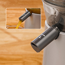 Handheld cordless vacuum cleaner with narrow nozzle attachment cleaning between wooden floorboards and along baseboard.