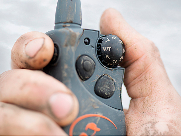 Dirty hand holding muddy SportDOG remote