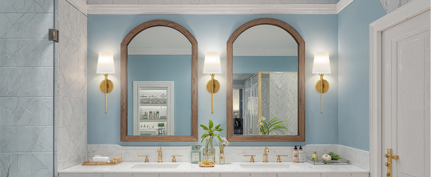 Luxury bathroom interior featuring three arched mirrors, marble countertops, light blue walls, and gold wall sconces with elegant fixtures.