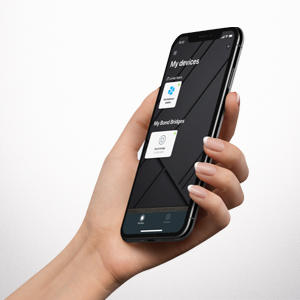 Hand holding smartphone with Bond Home ceiling fan app.