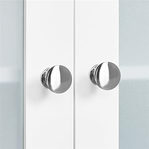 Two circular, metallic door handles or knobs mounted on white cabinets or doors. The handles have a split design with a brushed metal finish.