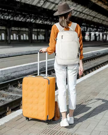 Immagini sequenziali di qualcuno che trasporta uno zaino o una borsa color marrone chiaro lungo quello che sembra essere un binario ferroviario o un ambiente industriale.