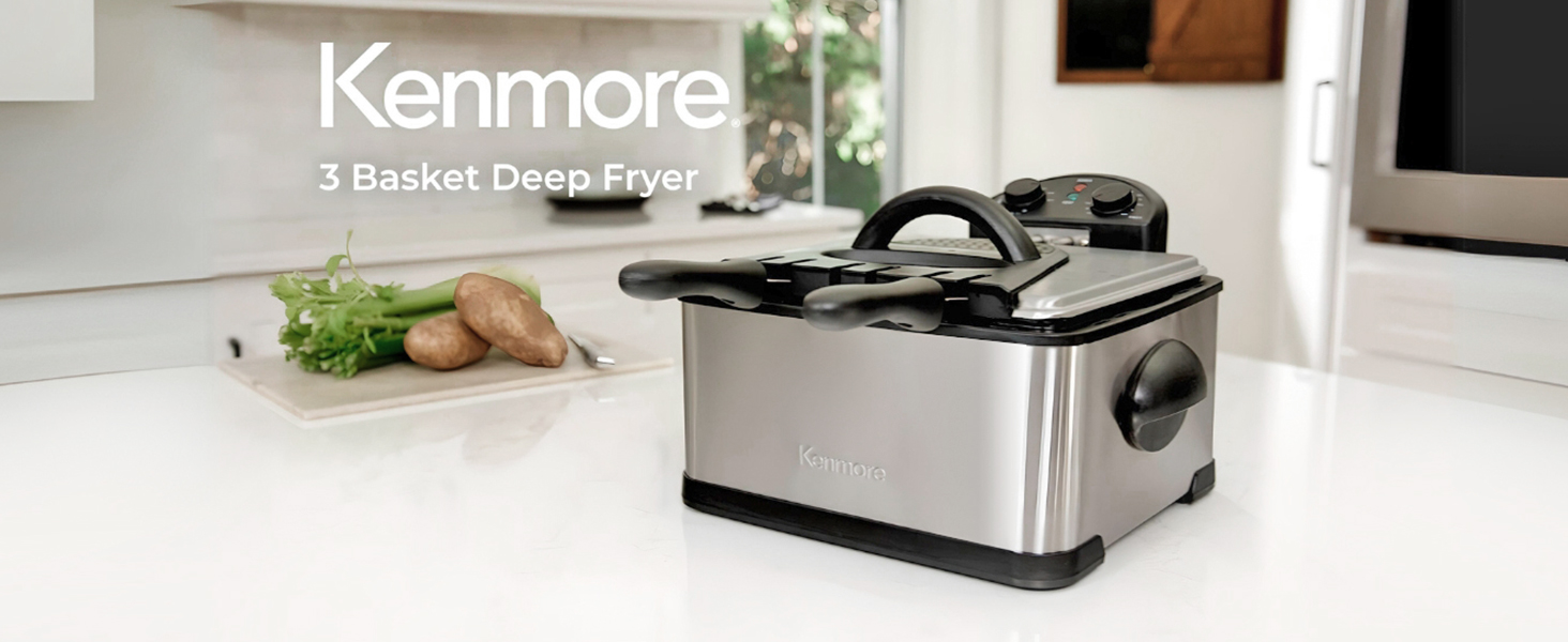 Deep fryer with fries in large basket and plates of food on either side on a white marble counter