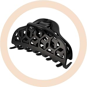Grande pince à cheveux en plastique noir avec motif géométrique hexagonal découpé sur fond circulaire couleur pêche