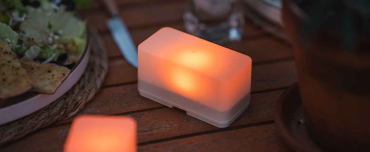 LED lights on table amongst a plate of food, silverware and a glass