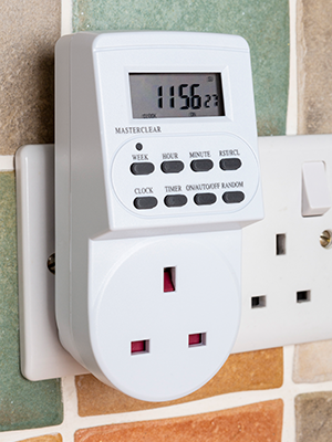 a white wall mounted electrical outlet with a digital clock.