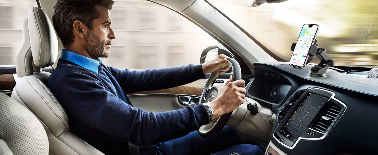 Person in suit driving while using mounted smartphone device on car dashboard, demonstrating mobile device usage in vehicle.