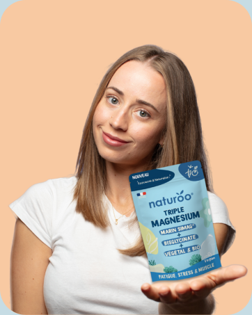 Boîte bleue de supplément Naturoo Triple Magnesium tenue par une personne en chemise blanche. L'emballage prétend favoriser la relaxation, réduire le stress et améliorer le sommeil.