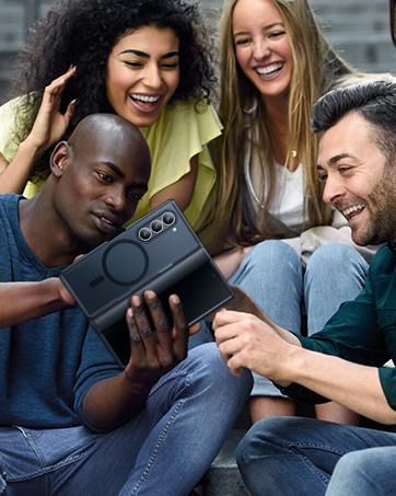 Group gathering viewing a black handheld gaming device or mobile console together on a casual couch setting.