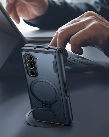 Black protective phone case with built-in ring holder or stand being demonstrated on a smartphone with triple camera setup.