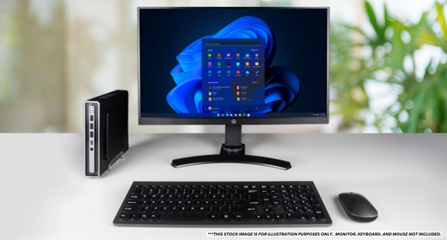 Envision M1 Mini PC sitting on a office desk, placed next to a monitor.