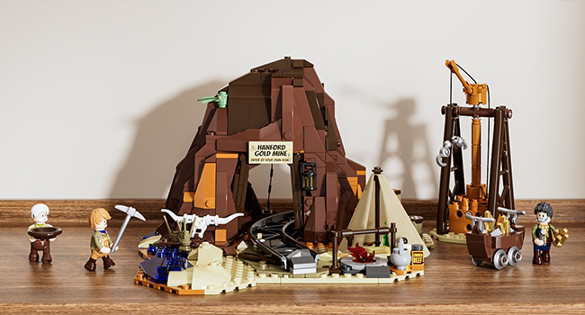 Spielzeugset mit Miniaturfiguren, einer braunen Bergstruktur, kleinen Fahrzeugen und Werkzeugen, die auf einem sandigen Untergrund angeordnet sind. Enthält ein Schild mit der Aufschrift „Ausgrabungsstätte“