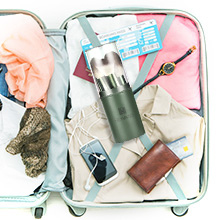 Open suitcase filled with travel essentials including clothes, toiletries, and accessories, showcasing efficient packing for a trip.