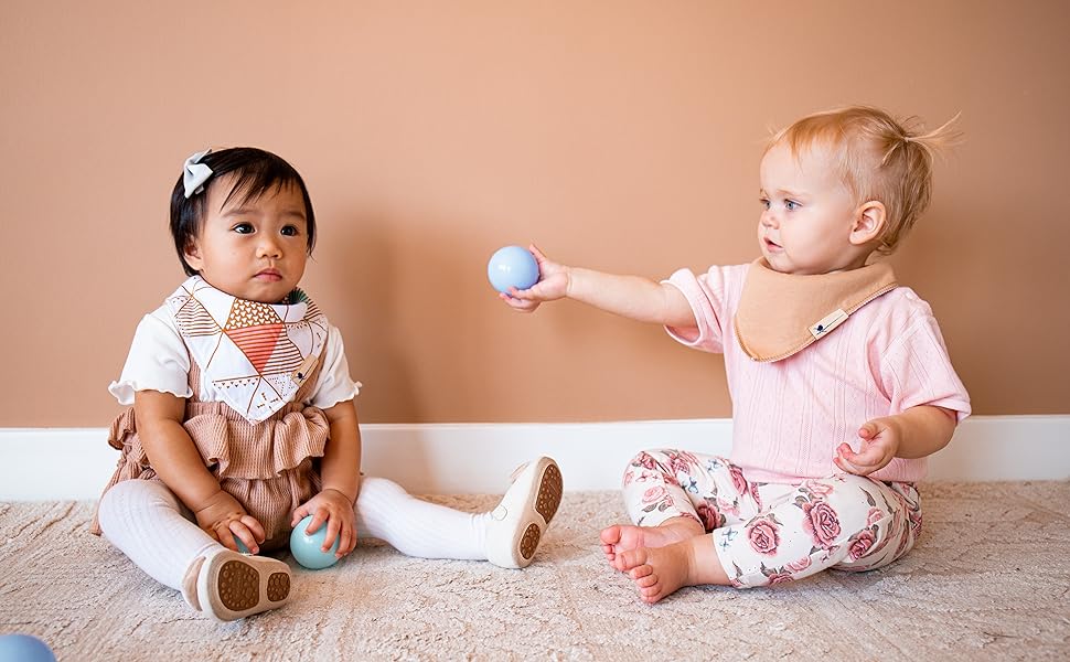Picture of two baby girls wearing Blue Wren Baby drool bibs with magnetic fasteners