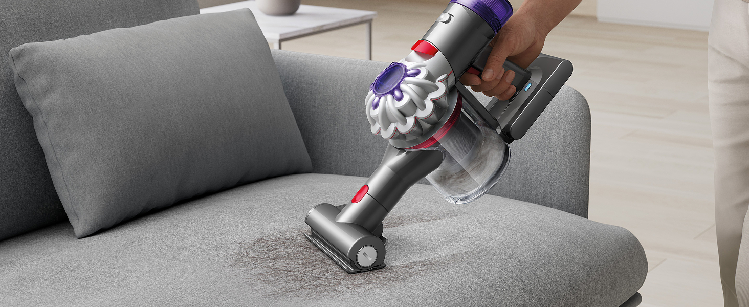 Aspiradora de mano Dyson Car+Boat eliminando la suciedad y el pelo de la tapicería.
