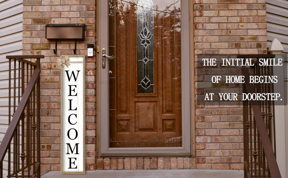 Wooden &#34;WELCOME&#34; sign with woodgrain frame hanging by brick door with glass panel.
