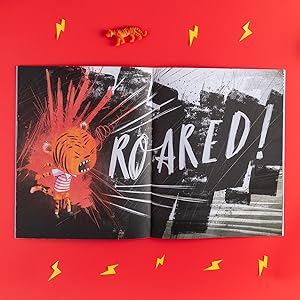 image of open book on red background with lightning bolts and tiger