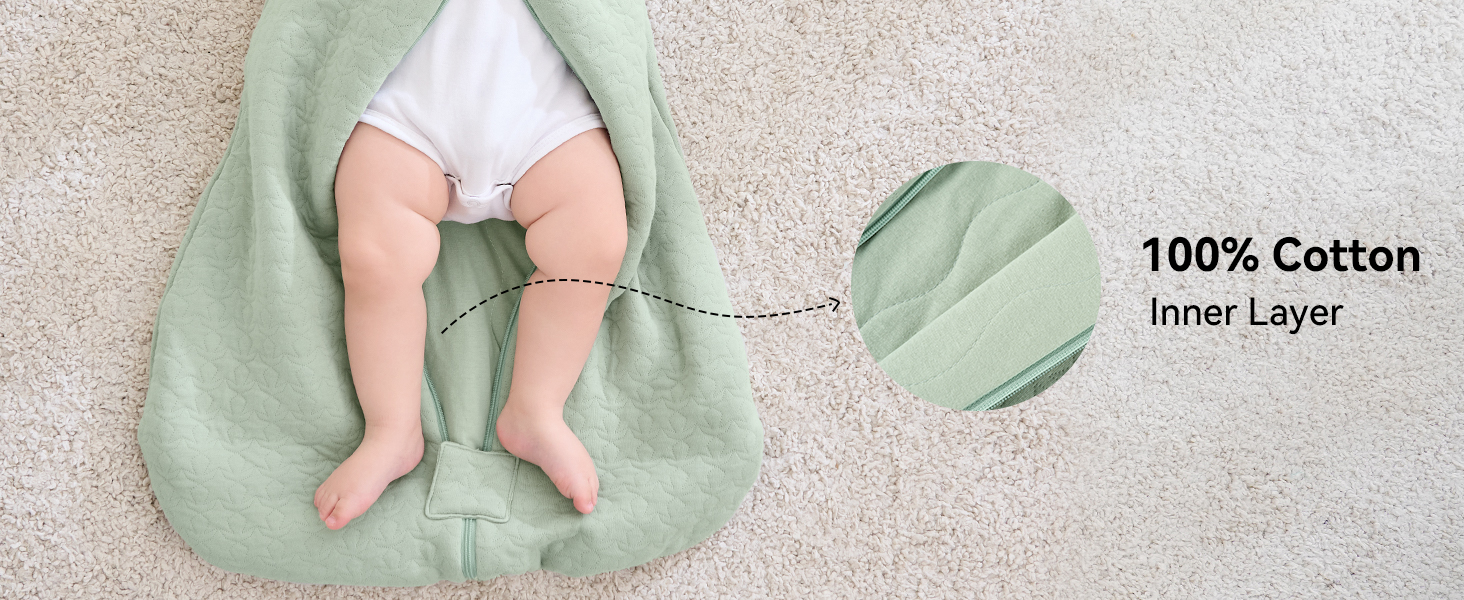 Salbeigrüner Babyschlafsack oder Wickeltuch mit einer Innenschicht aus 100% Baumwolle, gekennzeichnet durch eine detaillierte Aufschrift. Die Teilansicht zeigt sich öffnende Beine