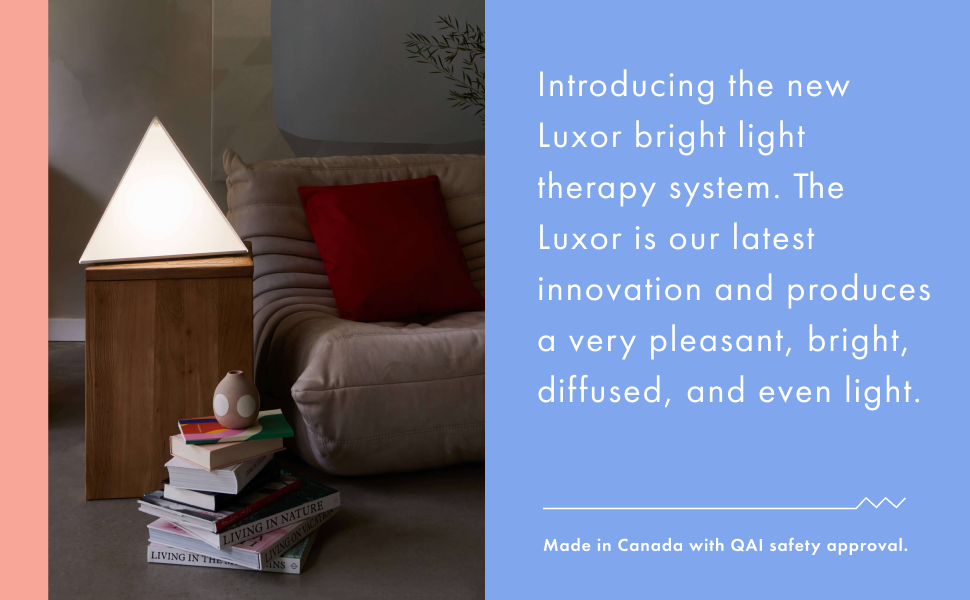 Luxor desk lamp on a pedestal. Bright light next to a low rise comfy couch with red pillow.