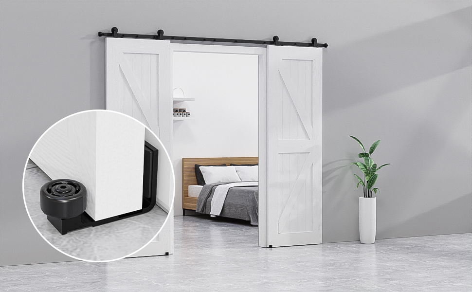 a white barn door with a black frame and a white bed in a room with a plant in the background.