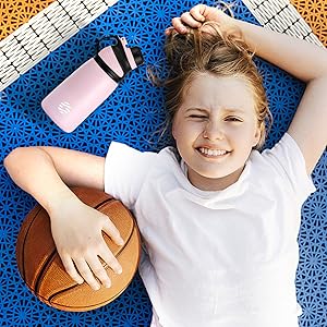 uma menina deitada em um tapete com uma bola de basquete e uma bola de basquete.