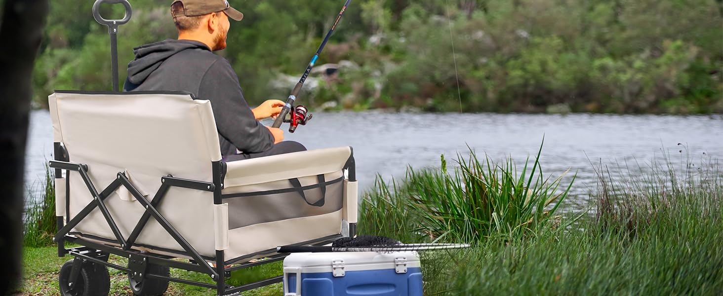 Person sitting in a portable outdoor folding wagon chair, fishing by a river. A blue cooler and fishing gear are visible nearby.