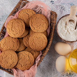 un cesto di biscotti accanto a una ciotola di uova e un bicchiere di latte.