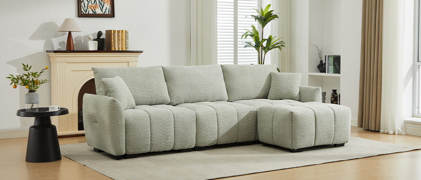Hellgraues modulares Ecksofa mit weicher, strukturierter Polsterung. Verfügt über eine Chaiselongue auf der rechten Seite und tiefe, bequeme Sitzkissen. Auf einem hellen Teppich in einem modernen Wohnzimmer positioniert