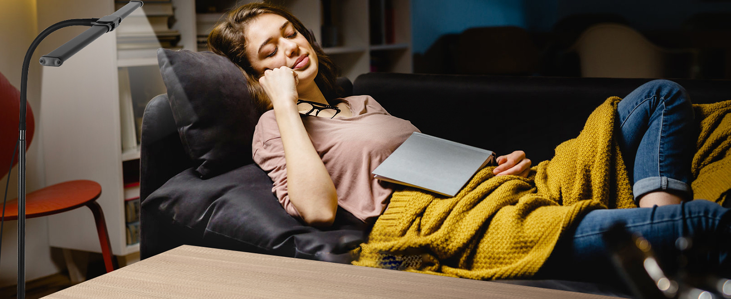 a woman sleeping on a couch with a book