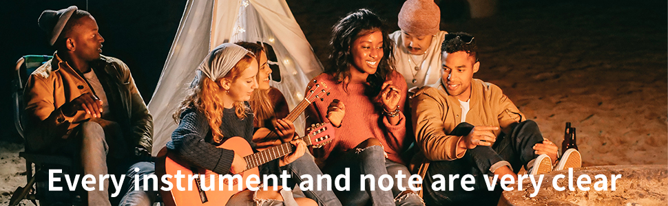 a group of friends sitting around a tent playing music