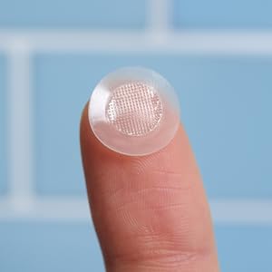 Finger tip with korean skincare salicylic acid pimple patch and blue tile background.