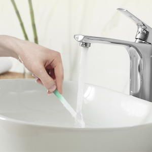 Glass file being cleaned in sink with water