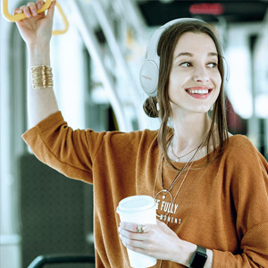 girl on a bus wearing creative zen hybrid, connected via bluetooth to mobile phone