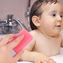 Close-up image of bath time scene with pink washing implement or scrubber being used.