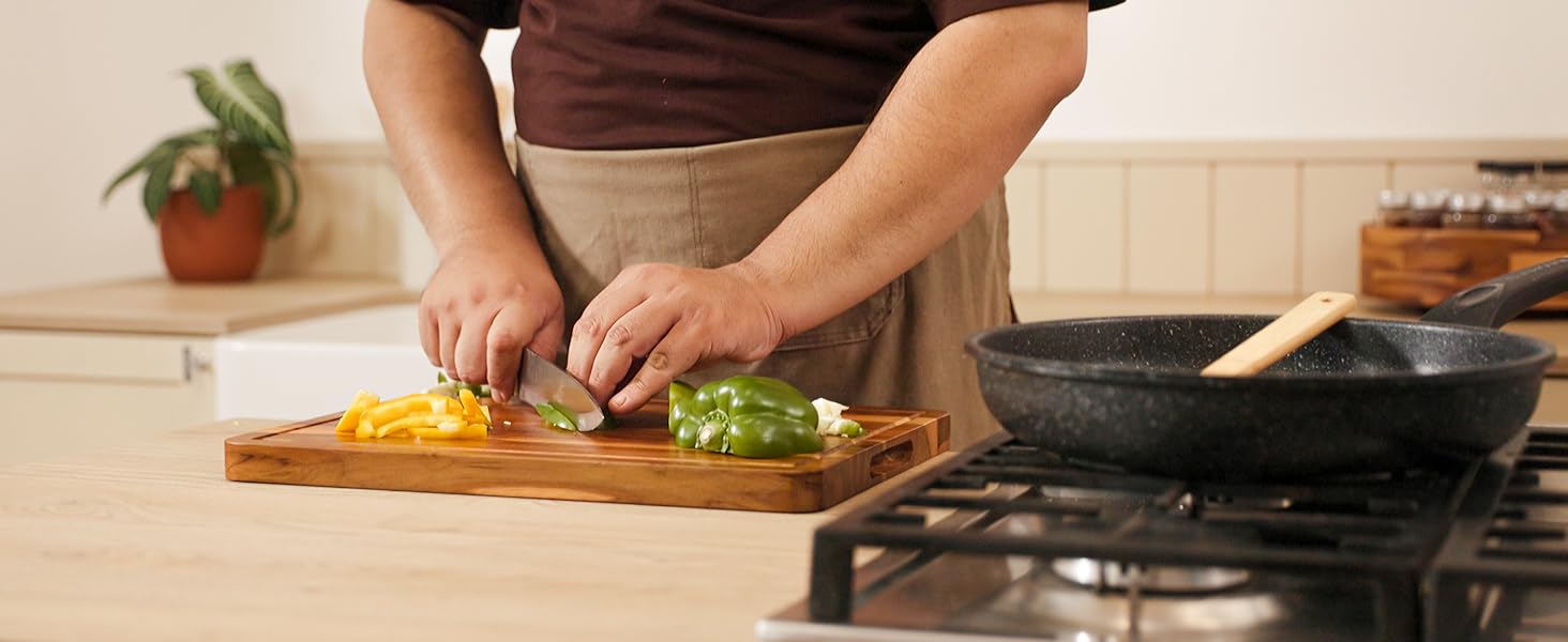 person cutting on teak cutting board