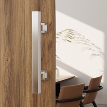 Moderner Türgriff oder Zugstange aus gebürstetem Metall, montiert auf einer Holzoberfläche. Minimalistisches, zeitgemäßes Design mit sichtbaren Befestigungselementen.