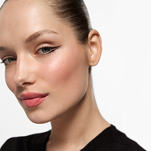 Professional beauty portrait showcasing flawless makeup application with winged eyeliner and natural-looking blush.