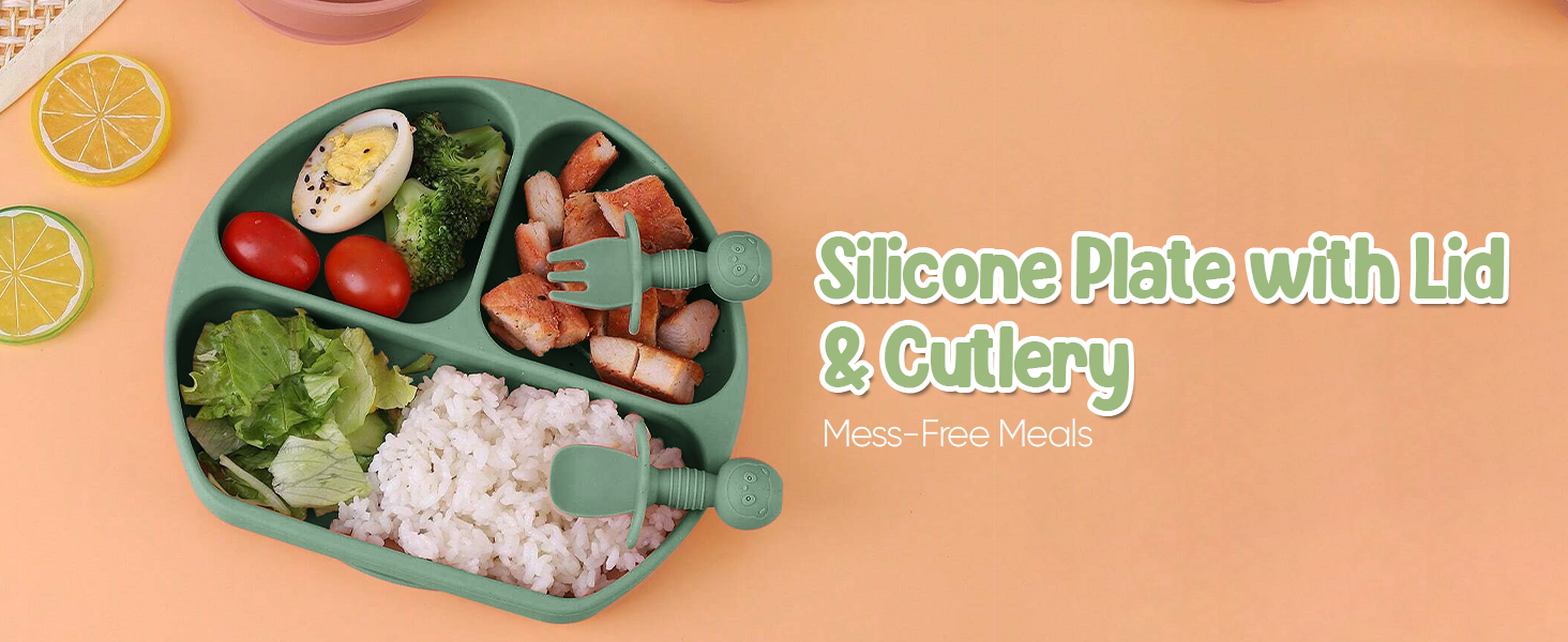 Sectioned silicone plate with lid and cutlery. Contains various food items including vegetables, meat, and lemon slices.