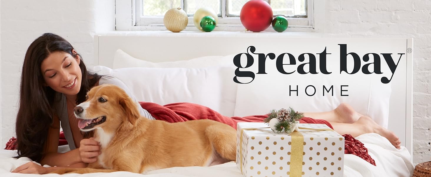 Mujer y perro en una cama rodeados de regalos